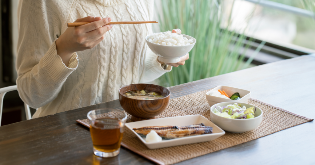テーブルでバランスの良い和食を食べる女性。