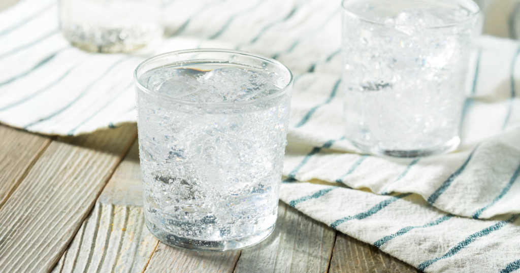 木の机に置かれたガラスのコップに入った炭酸水
