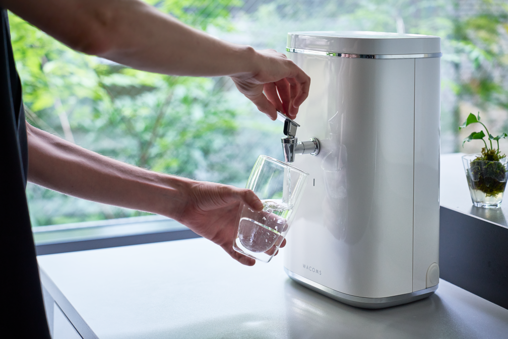 逆浸透膜浄水器WACOMS TRUSTから水を汲む様子