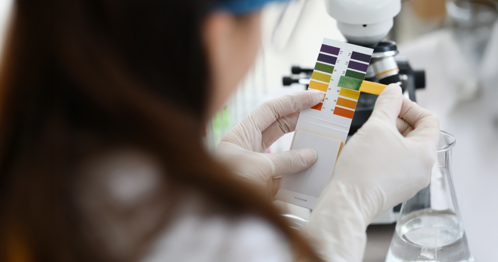 研究室で女性がリトマス試験紙を使っている風景写真