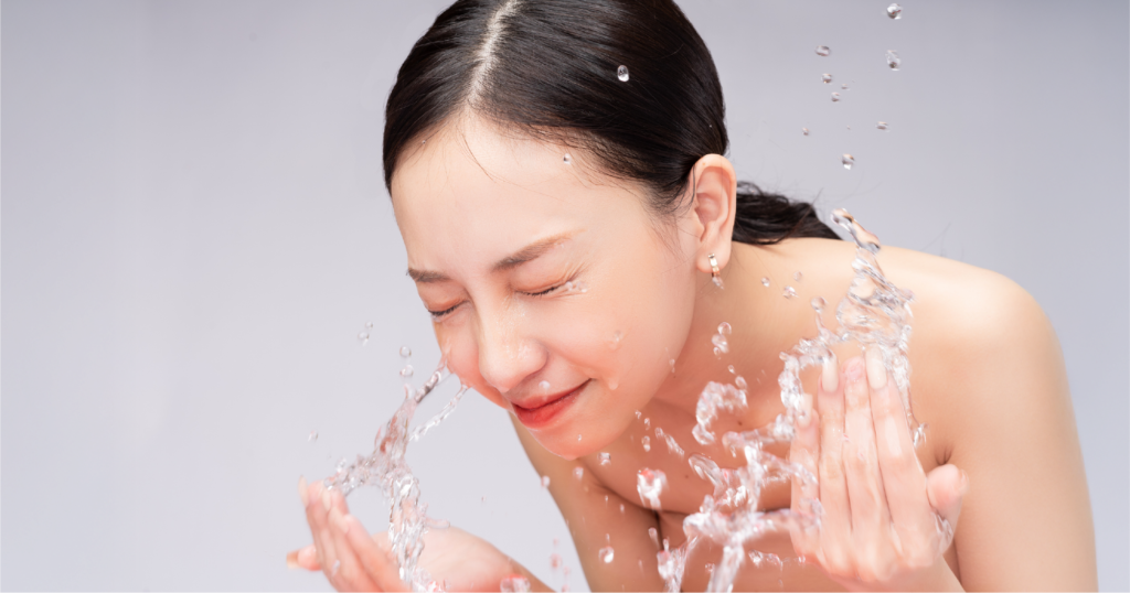 女性が水で顔を洗っている様子