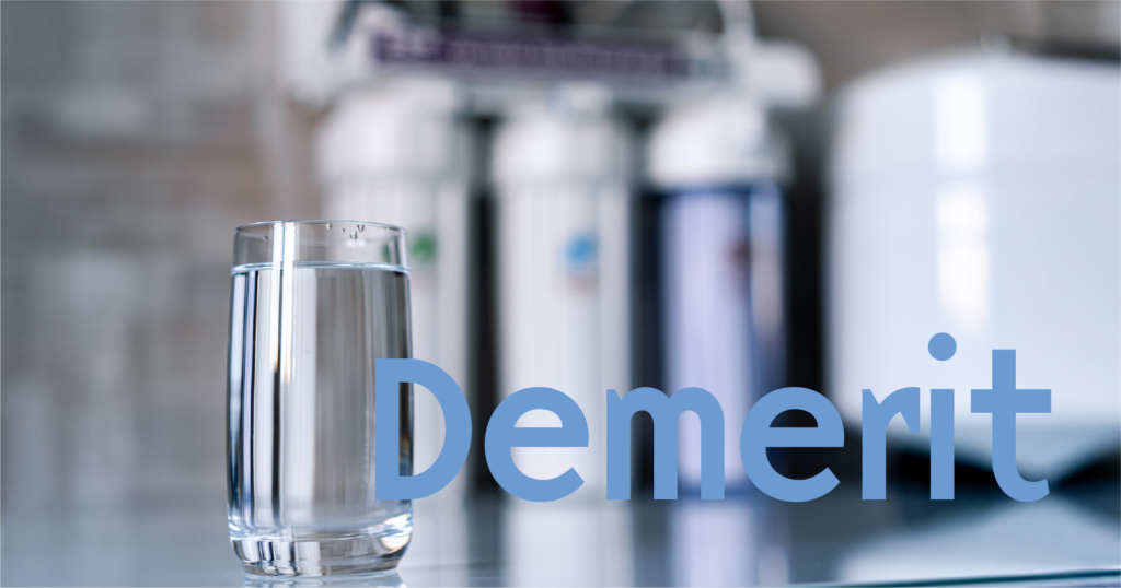 逆浸透膜浄水器のタンクとフィルターの背景と、手前にガラスのコップに入った水。Demeritの文字。