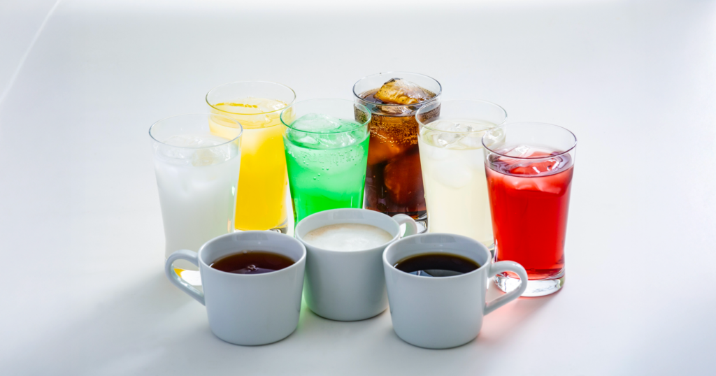 ガラスのコップや陶器のカップに注がれた多種多様な清涼飲料水の写真
