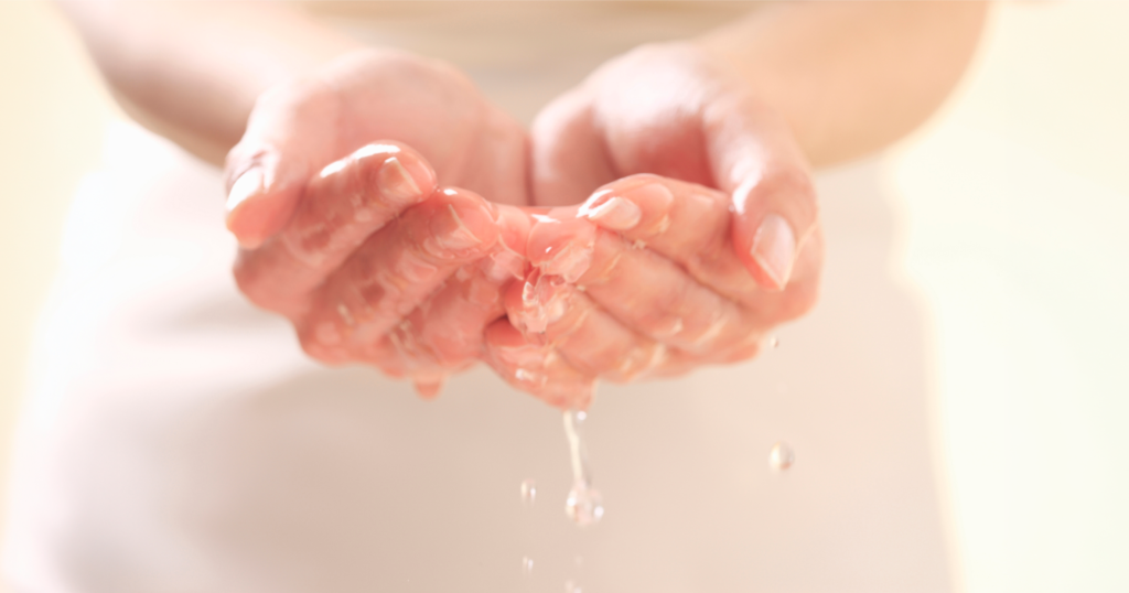 女性が両手で水を掬っている写真