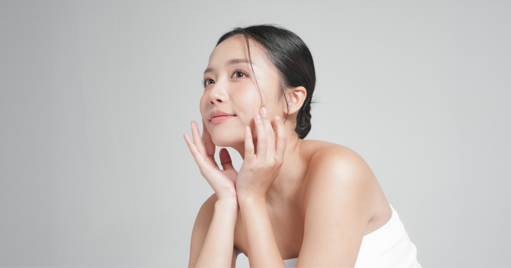 綺麗な肌の女性が頬に両手を添えている写真