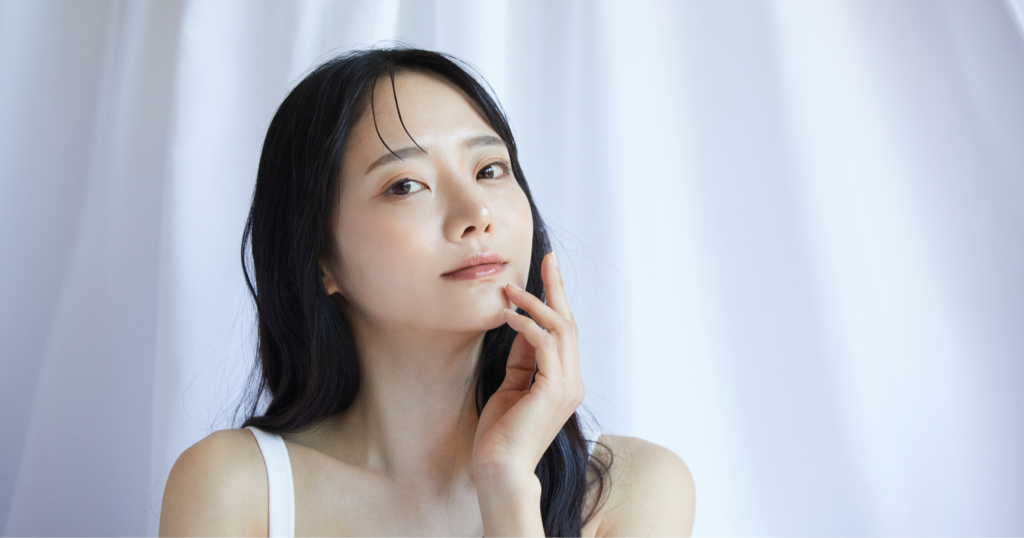 女性が顎にに片手を添えている写真