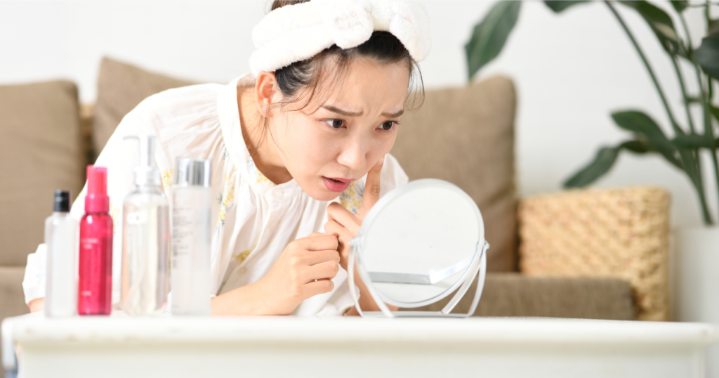 鏡を見つめて肌の調子を確認している様子。